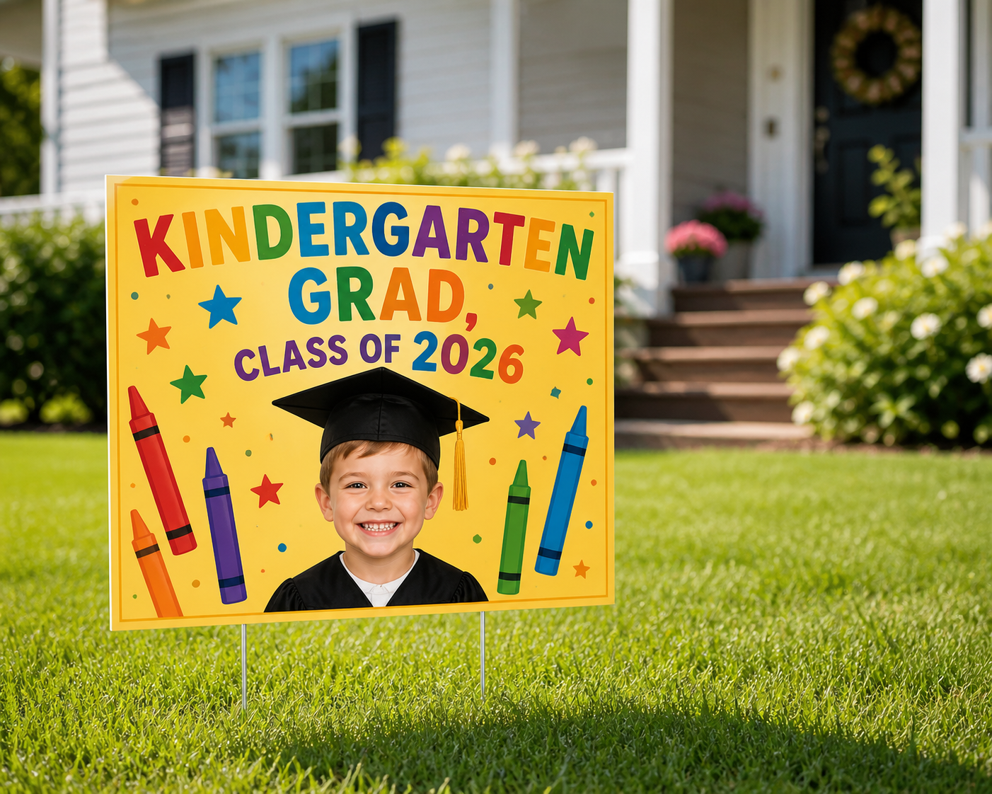 Bright yellow kindergarten graduation yard sign with a student photo and colorful crayon graphics