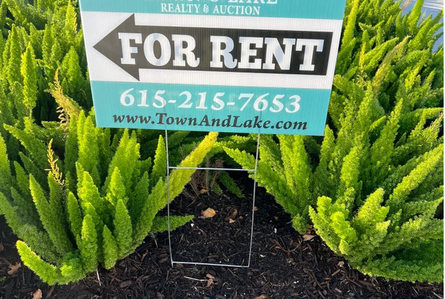 a yard sign with wire stakes in the ground